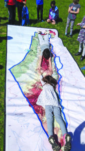 Beth Am students lie on a map of Israel