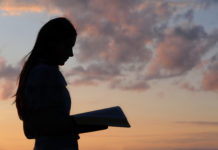 a woman studies against the sunset