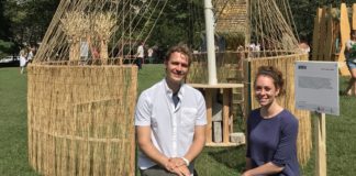 Architects Jordan Billingsley and Esther Furman crouch in front of their unconventional sukkah, titled “Woven"
