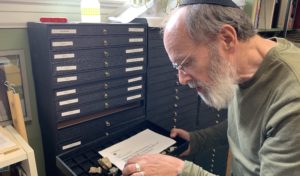 Arthur Kurzweil looks through the drawers that store his collection
