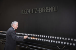 Holocaust survivor Alfred Munzer lights a candle at Holocaust commemoration event
