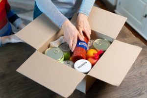 A person putting cans into a box