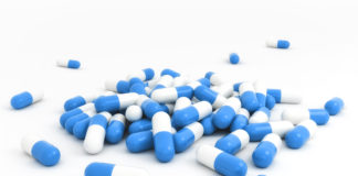 White and blue capsules spilled over white background