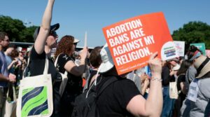 A protester holds a sign saying “Abortion bans are against my religion”