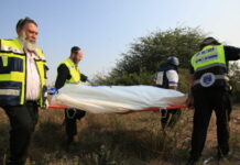Medical responders carry a body bag in Sderot, Israel