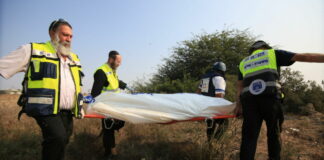 Medical responders carry a body bag in Sderot, Israel