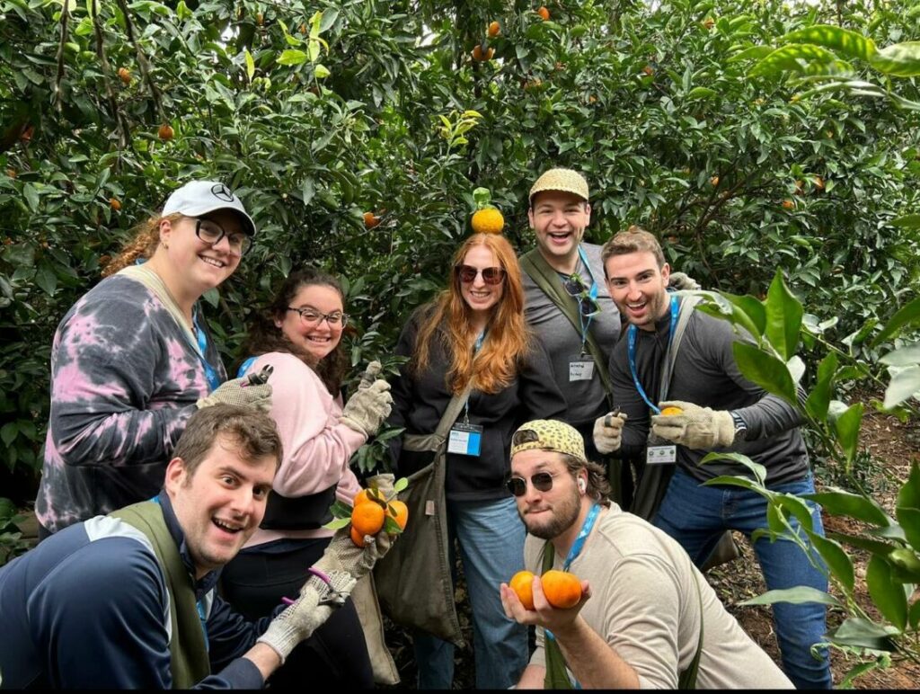 Young adults on Birthright hold oranges in Israel