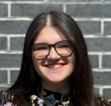 I Grew up in Berlin, Escaped Terror in Israel and Was Called ‘Disgusting Jew’ in New York. Where Can I Feel Safe? Photo of a girl with straight dark hair and black glasses smiling at the camera in front of a brick wall.