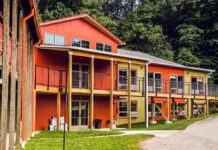 Photo of a reddish-brown three-story building that resembles a long house.