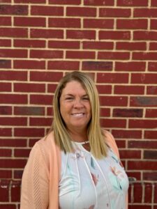 Tami Scherr stands in front of brick wall