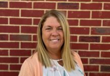 Tami Scherr stands in front of brick wall