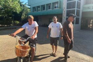 Three people standing outdoors
