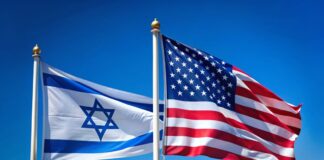 Two flags, one of which is the American flag and the other is the Israeli flag, are flying side by side