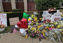 Opinion: 7 Years Later, the Unseen Gravity of Memory Flowers on a makeshift memorial.