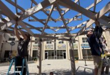 People decorating the Attman family sukkah at Chizuk Amuno.