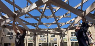 People decorating the Attman family sukkah at Chizuk Amuno.