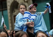 Two young children holding an Israeli flag.