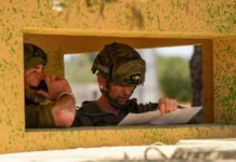 Two soldiers wearing green helmets.