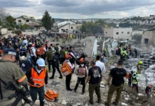 A group of first responders at the site of a missile strike.