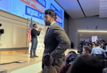 Hasan Piker looks on as U.S. Senate candidate Abdul El-Sayed delivers a stump speech in Ann Arbor, Michigan, April 7, 2026. Piker, a popular Twitch streamer accused of antisemitism, prompted controversy for campaigning with El-Sayed.