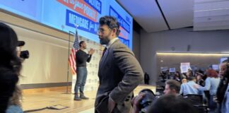 Hasan Piker looks on as U.S. Senate candidate Abdul El-Sayed delivers a stump speech in Ann Arbor, Michigan, April 7, 2026. Piker, a popular Twitch streamer accused of antisemitism, prompted controversy for campaigning with El-Sayed.