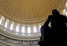 The interior of the U.S. Capitol rotunda from behind a statue of founding father and first president George Washington. The image captures a portion of Constantino Brumidi’s “Frieze of American History” starting from “Pizarro Going to Peru” to the beginning of “Landing of the Pilgrims.”